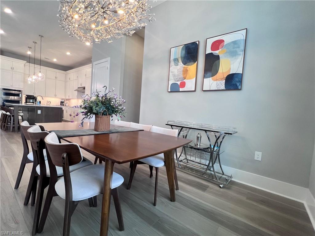 9124 Raintree Street Naples, FL 34114 - Photo 7 of 42 a view of a dining room with furniture and wooden floor