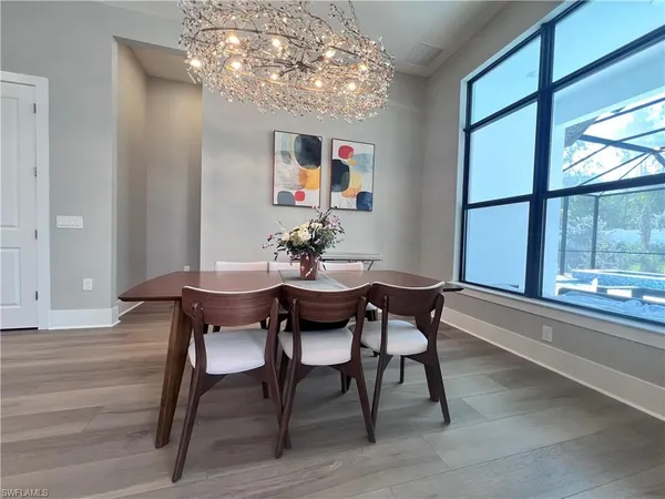 a dining room with furniture a chandelier and wooden floor