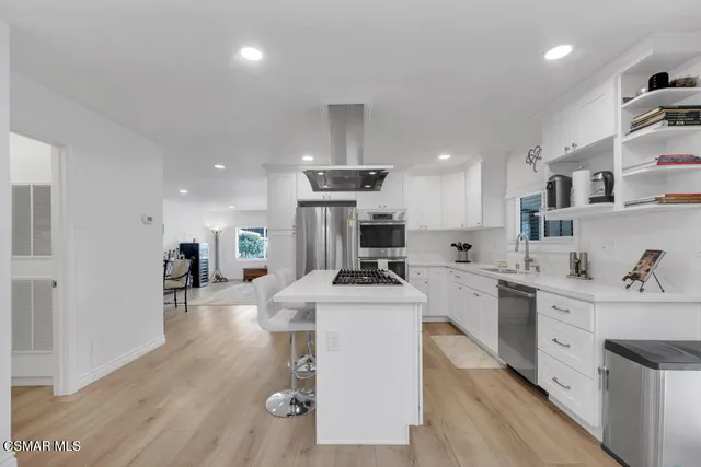 a kitchen with stainless steel appliances kitchen island granite countertop a sink and cabinets