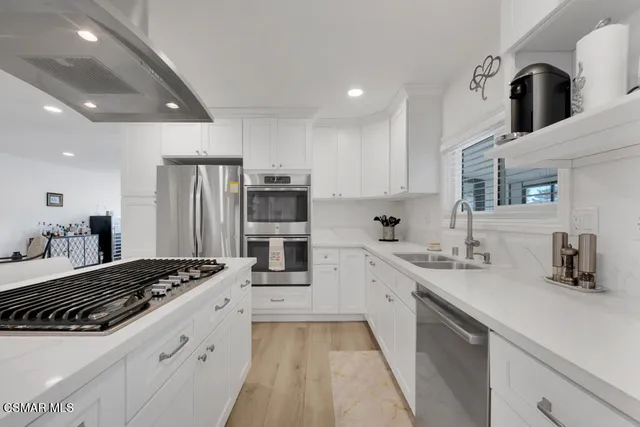 a kitchen with stainless steel appliances granite countertop a sink a stove and a refrigerator