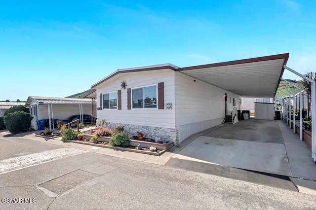 a view of a house with backyard and sitting area