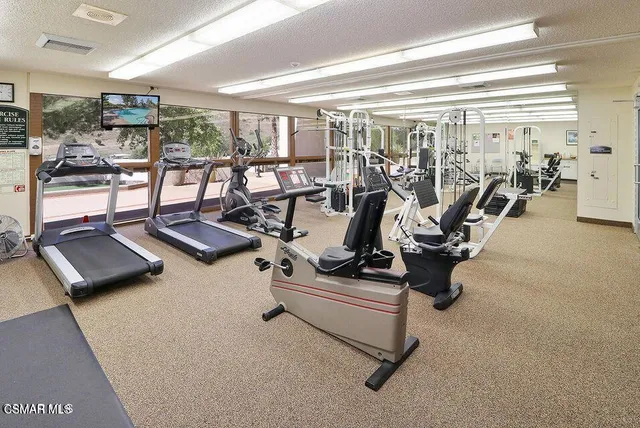 a picture of a room with a white bed and a white refrigerator