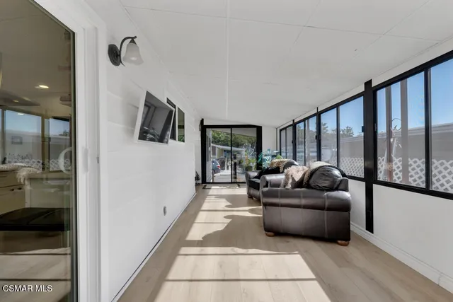 a living room with furniture floor to ceiling window and flat screen tv