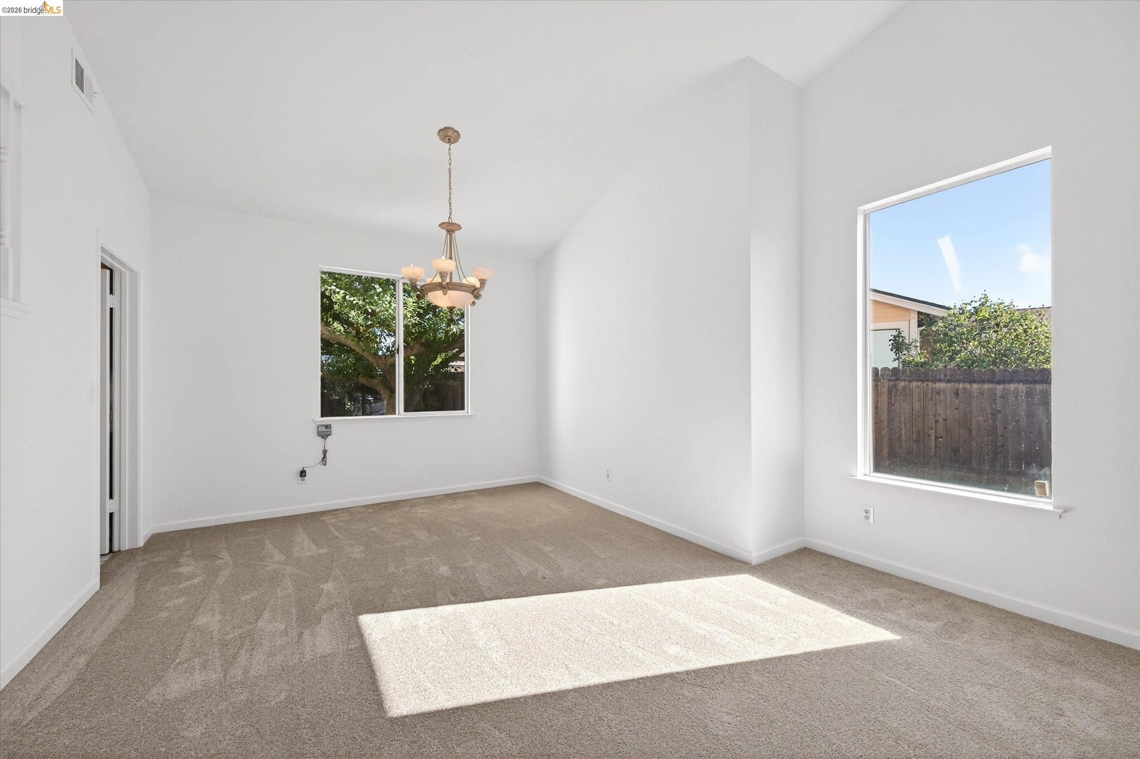1120 Deerpark Road Oakley, CA 94561 - Photo 8 of 30 Spacious room featuring vaulted ceilings, neutral-toned carpeting, and a traditional chandelier