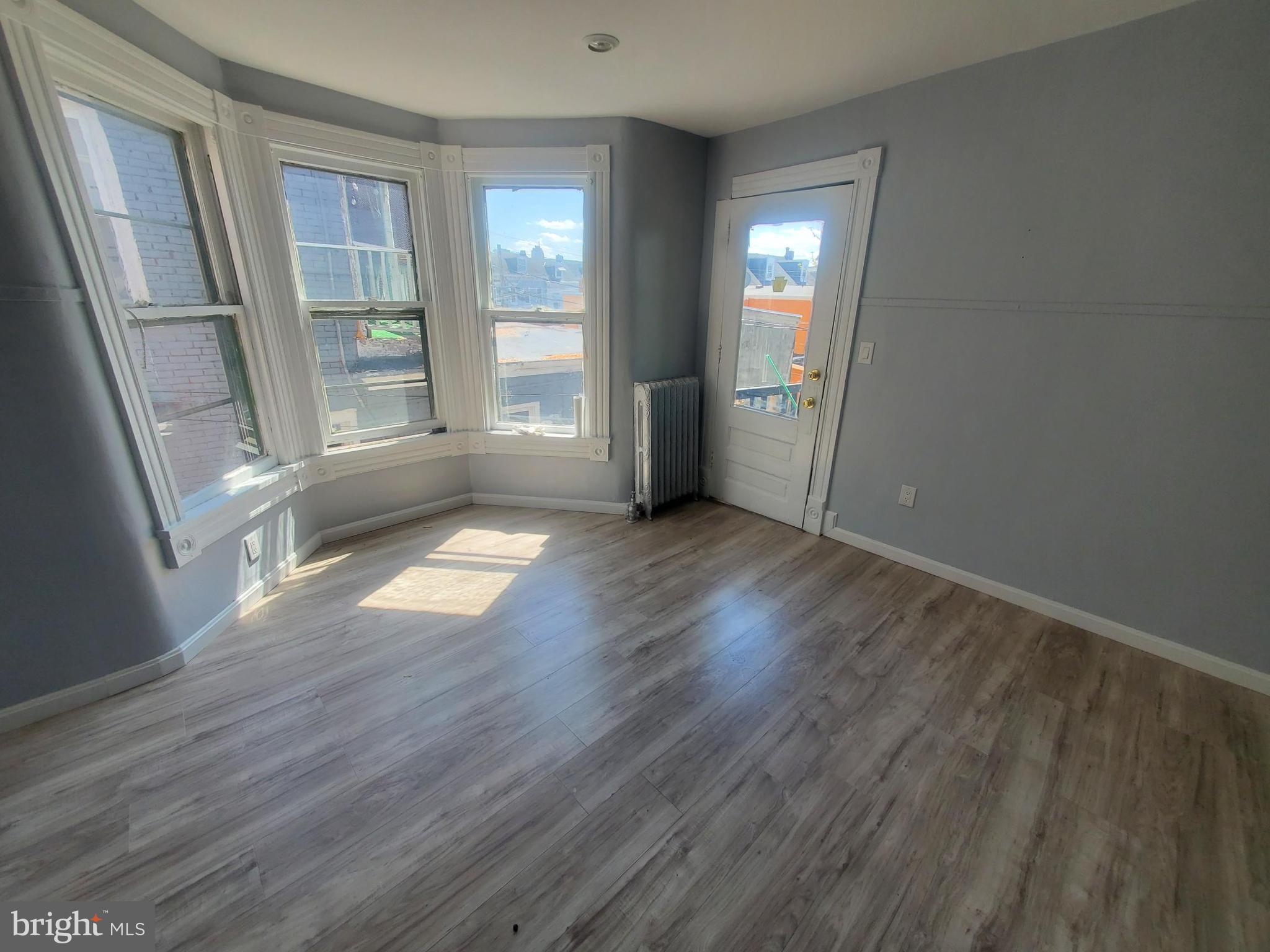 608 North 10th Street, Unit 2 Reading, PA 19604 - Photo 4 of 15 an empty room with wooden floor and windows
