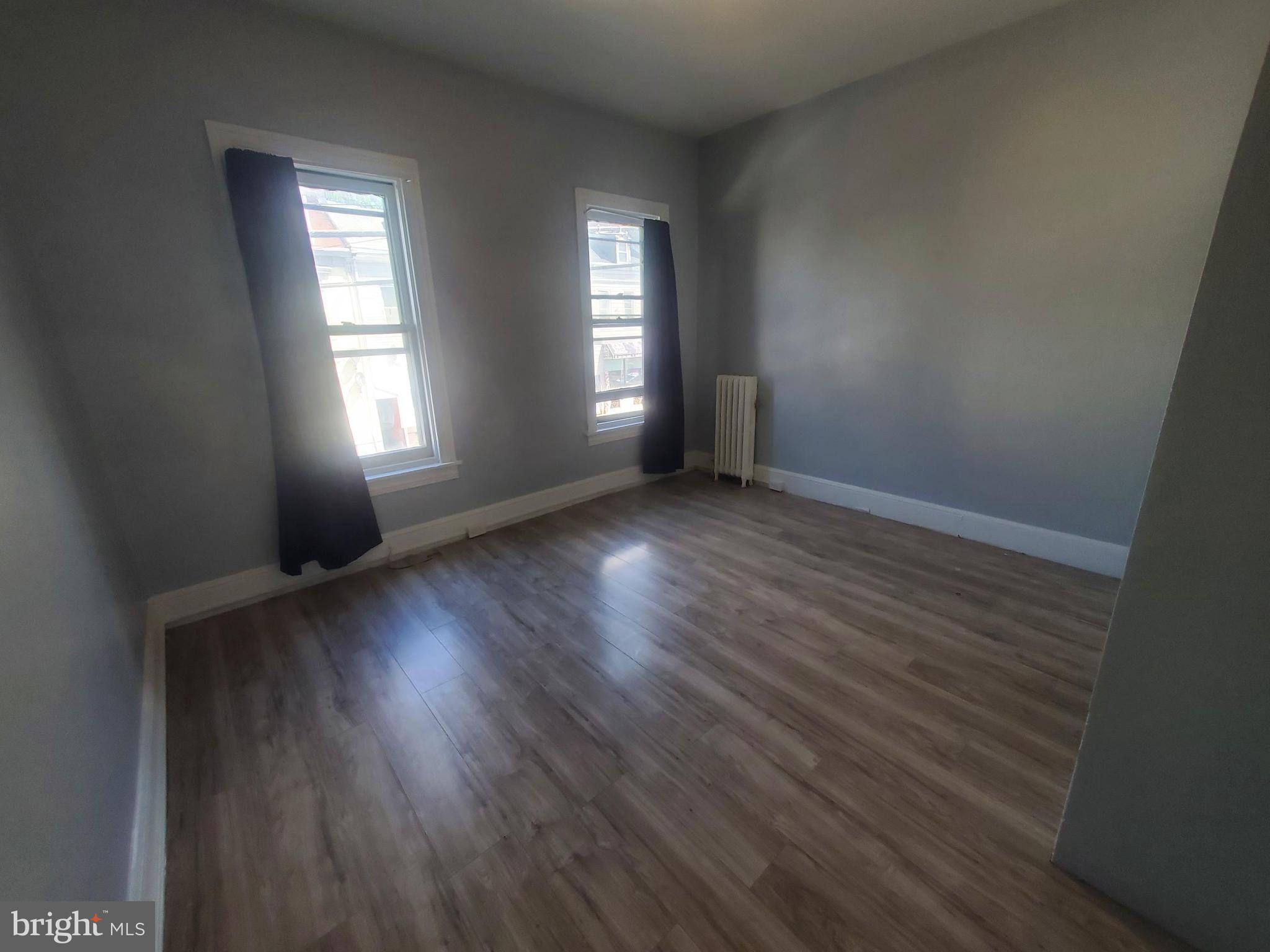 608 North 10th Street, Unit 2 Reading, PA 19604 - Photo 10 of 15 an empty room with wooden floor and windows