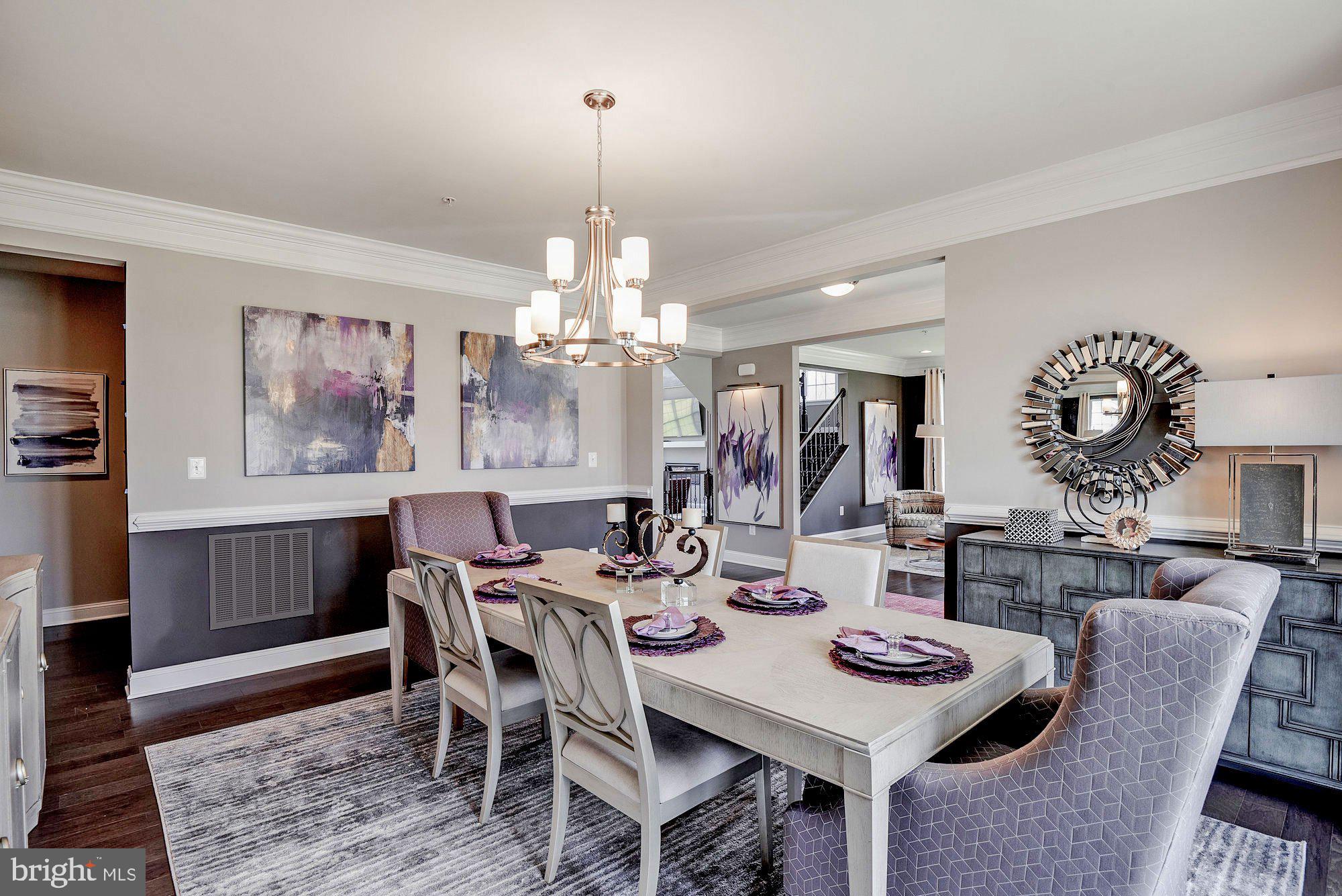 5705 Iron Stone Road Lothian, MD 20711 - Photo 14 of 17 a view of a dining room with furniture a chandelier and wooden floor