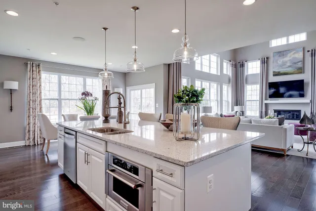 a kitchen with stainless steel appliances granite countertop a sink a stove and wooden floor