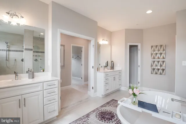 a spacious bathroom with a double vanity sink a mirror a bathtub and
