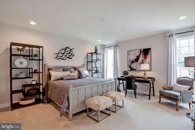 a bedroom with a bed a table and painting on the wall