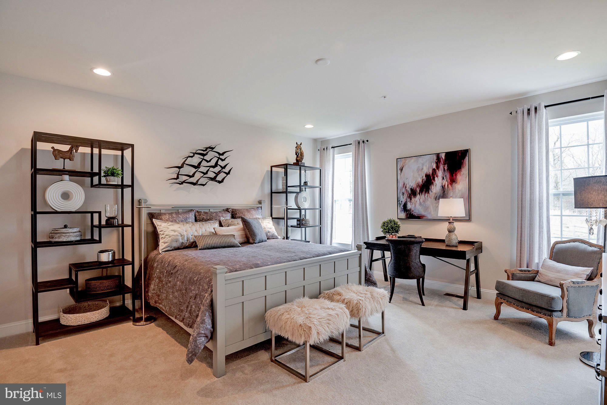 5705 Iron Stone Road Lothian, MD 20711 - Photo 9 of 17 a bedroom with a bed a table and painting on the wall