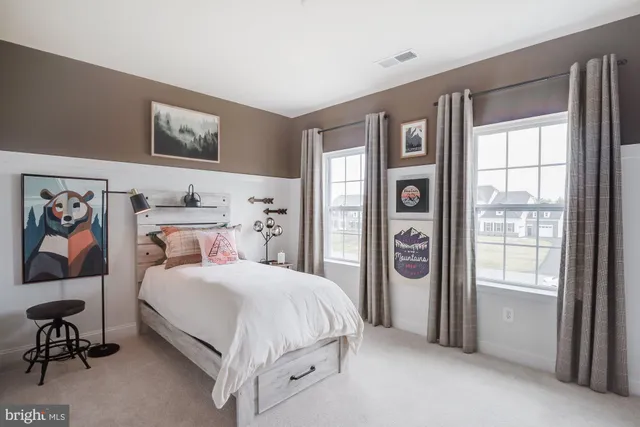 a bedroom with a bed and a painting on the wall