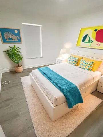 a bedroom with a bed and painting on the wall