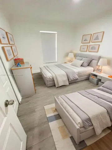 a bedroom with two beds and painting on the wall