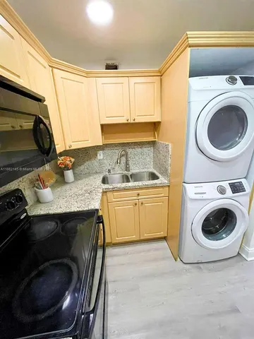 a utility room with sink dryer and washer