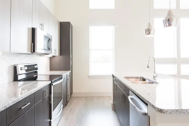 a kitchen with stainless steel appliances granite countertop a sink stove and refrigerator