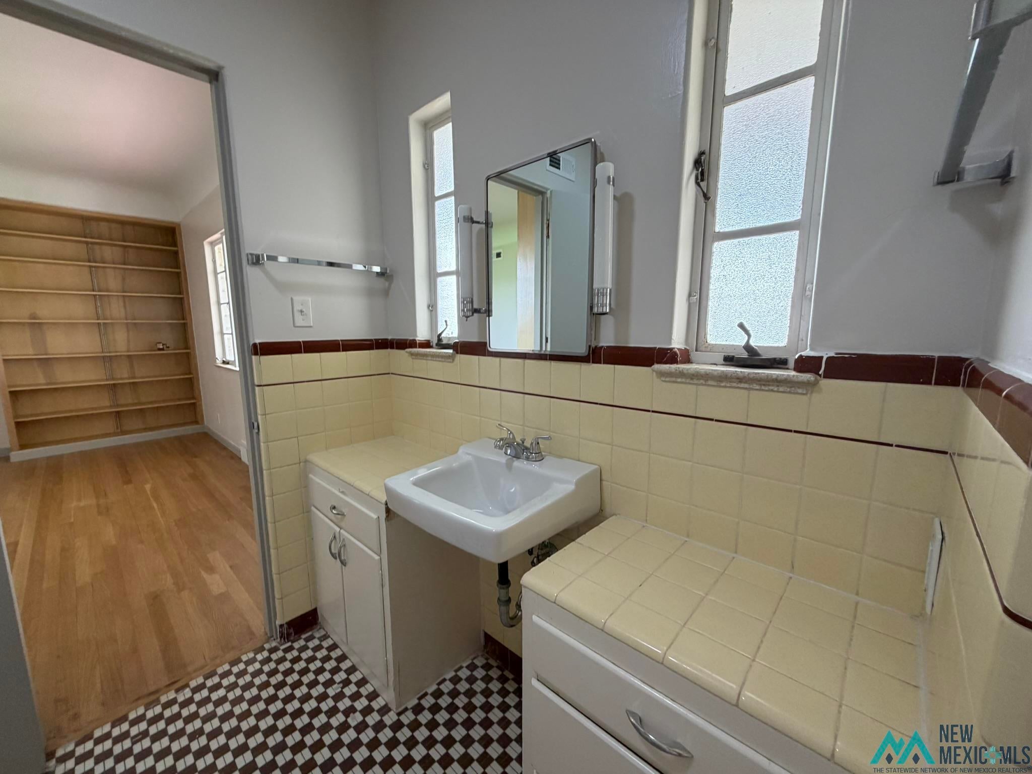 570 Curry Road North Clovis, NM 88101 - Photo 23 of 59 Bathroom featuring a checkered tile floor, pedestal sink, and tiled countertops