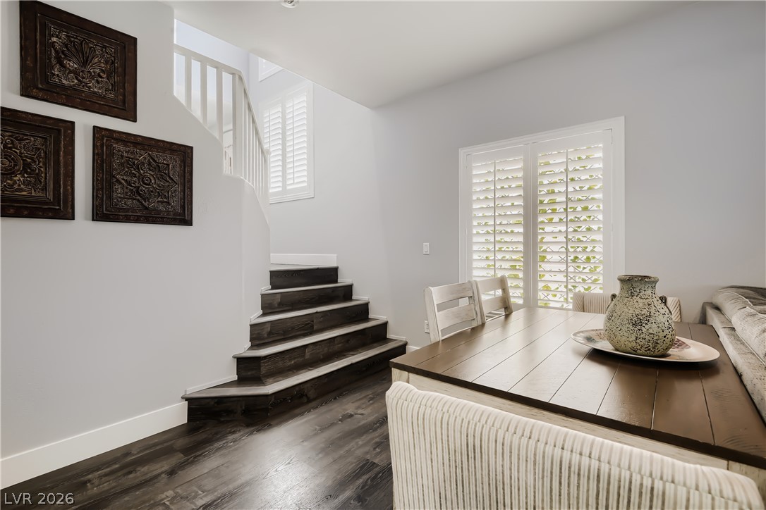 251 Integrity Ridge Drive Henderson, NV 89052 - Photo 8 of 28 Elegant dark wood flooring grounds this open dining area with a gracefully curved staircase and natural light.