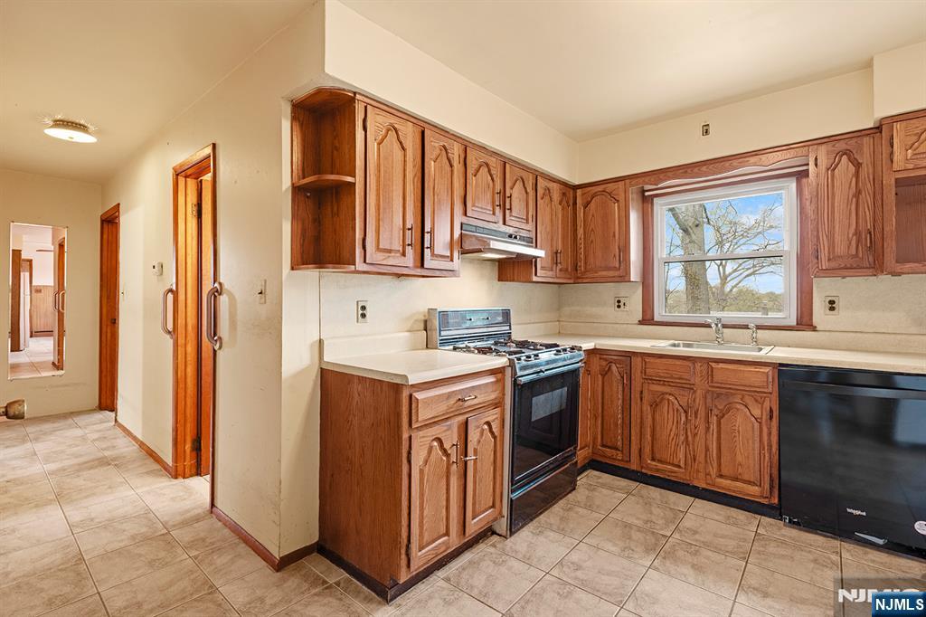 677 Greeley Avenue Fairview, NJ 07022 - Photo 11 of 34 a kitchen with stainless steel appliances granite countertop a stove a sink and a refrigerator