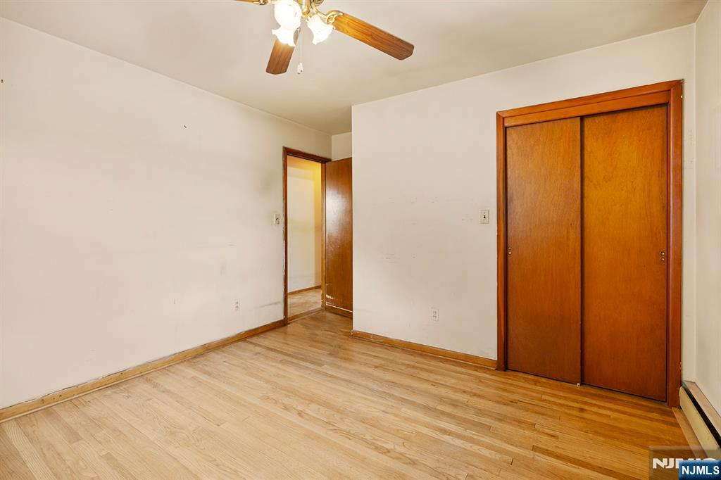 677 Greeley Avenue Fairview, NJ 07022 - Photo 13 of 34 an empty room with wooden floor closet and windows