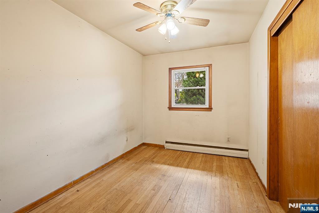 677 Greeley Avenue Fairview, NJ 07022 - Photo 16 of 34 a view of an empty room with wooden floor and a window