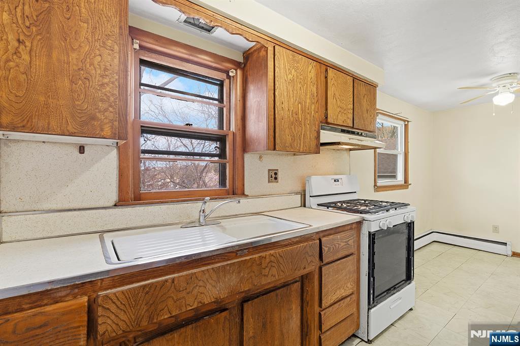 677 Greeley Avenue Fairview, NJ 07022 - Photo 21 of 34 a kitchen with a sink stove and cabinets