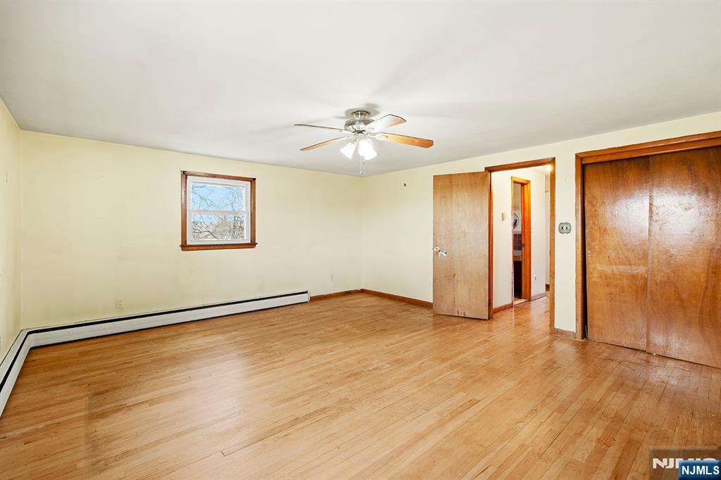 677 Greeley Avenue Fairview, NJ 07022 - Photo 25 of 34 a view of an empty room with a window and a ceiling fan