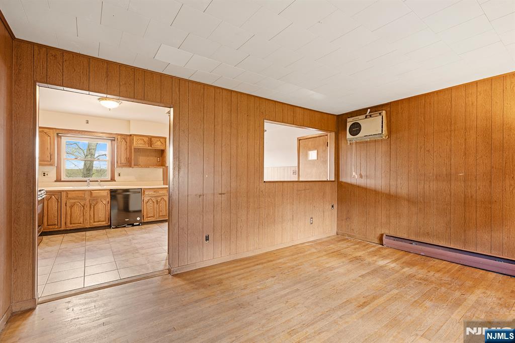 677 Greeley Avenue Fairview, NJ 07022 - Photo 4 of 34 a view of a livingroom with wooden floor and kitchen space