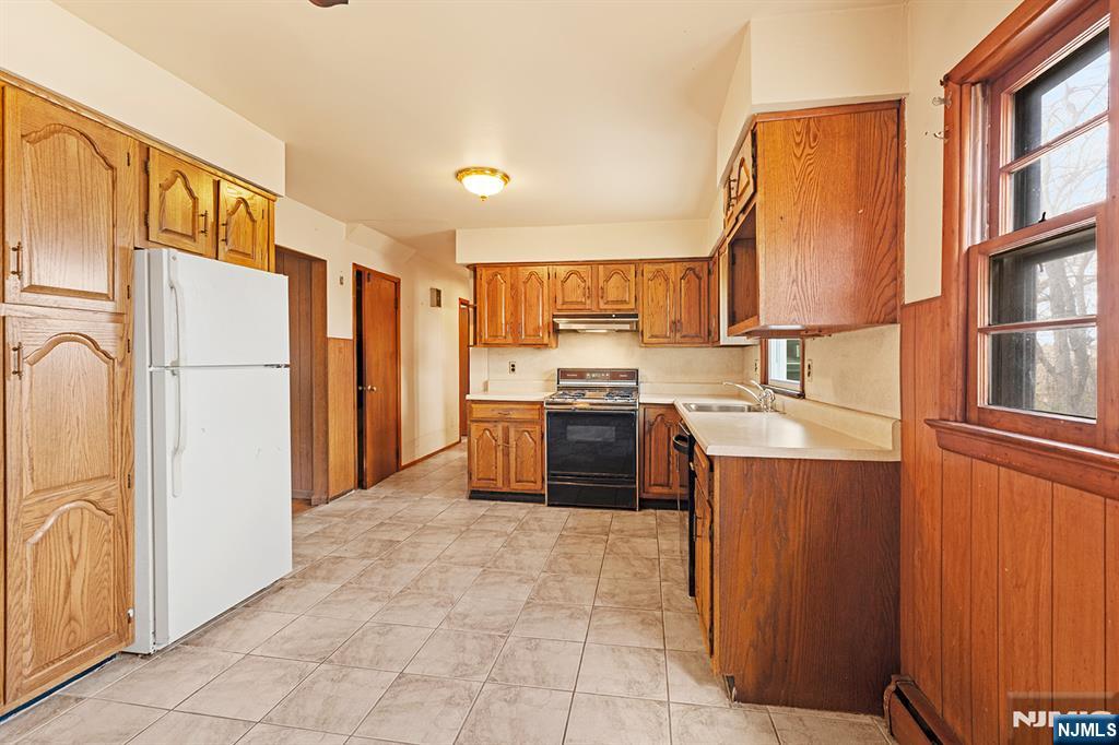 677 Greeley Avenue Fairview, NJ 07022 - Photo 9 of 34 a kitchen with stainless steel appliances granite countertop a refrigerator a sink and a stove