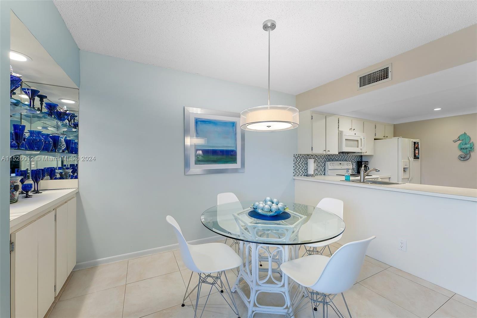 1605 Highway 1, Unit A406 Jupiter, FL 33477 - Photo 11 of 26 a kitchen with a dining table and chairs in it