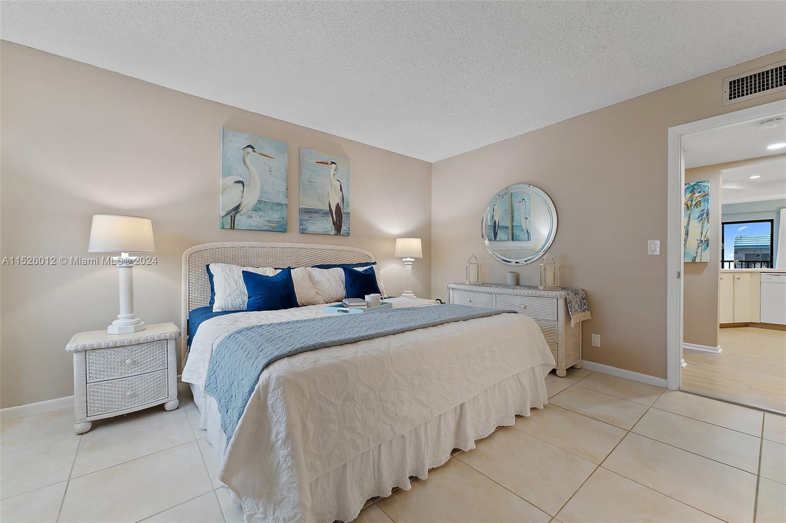 1605 Highway 1, Unit A406 Jupiter, FL 33477 - Photo 16 of 26 a bedroom with a bed and a lamp