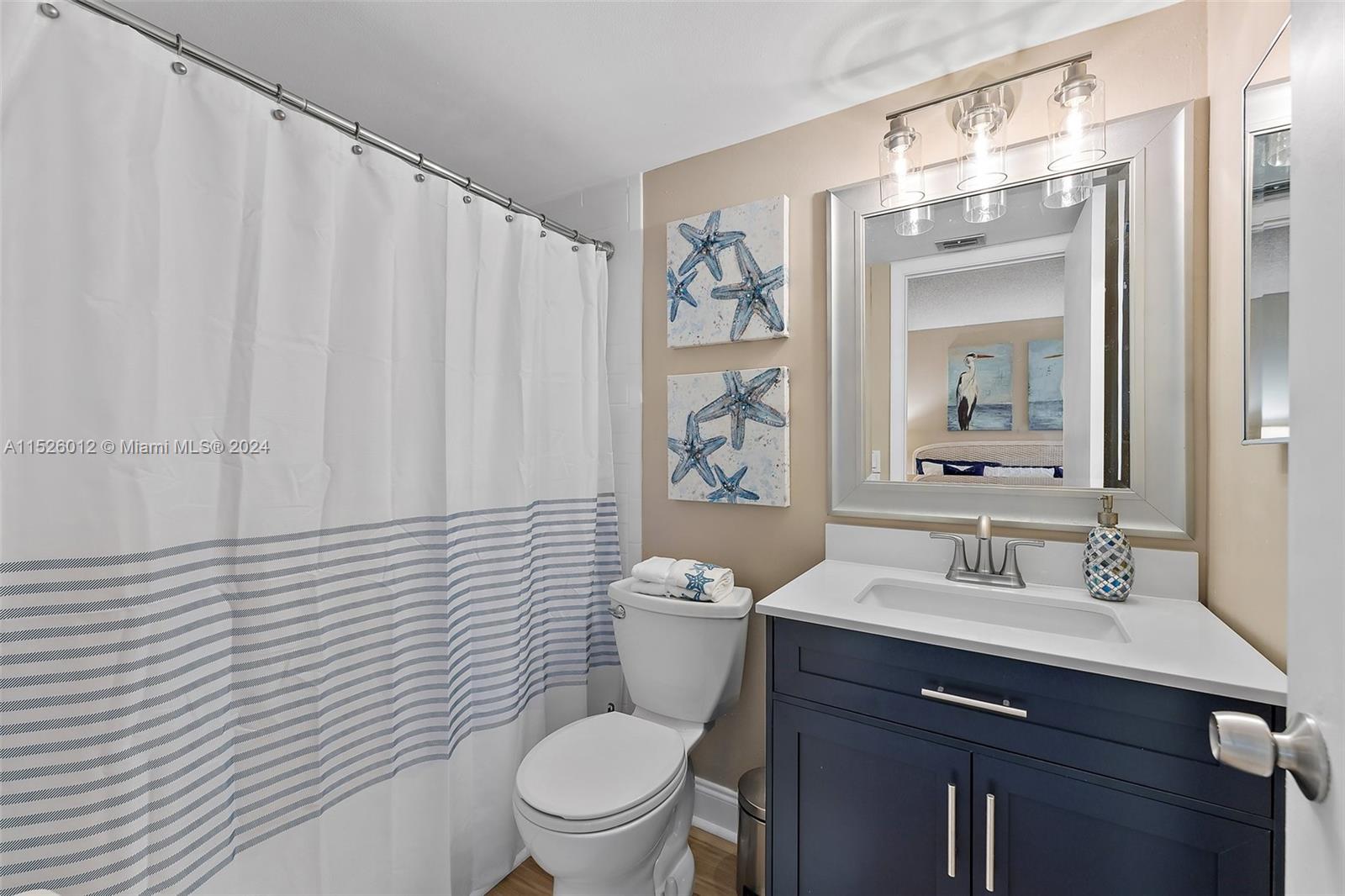 1605 Highway 1, Unit A406 Jupiter, FL 33477 - Photo 19 of 26 a bathroom with a toilet a sink and a mirror