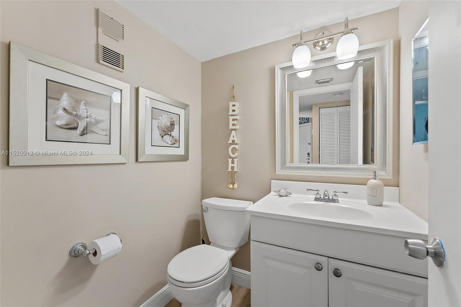 1605 Highway 1, Unit A406 Jupiter, FL 33477 - Photo 20 of 26 a bathroom with a toilet sink and mirror