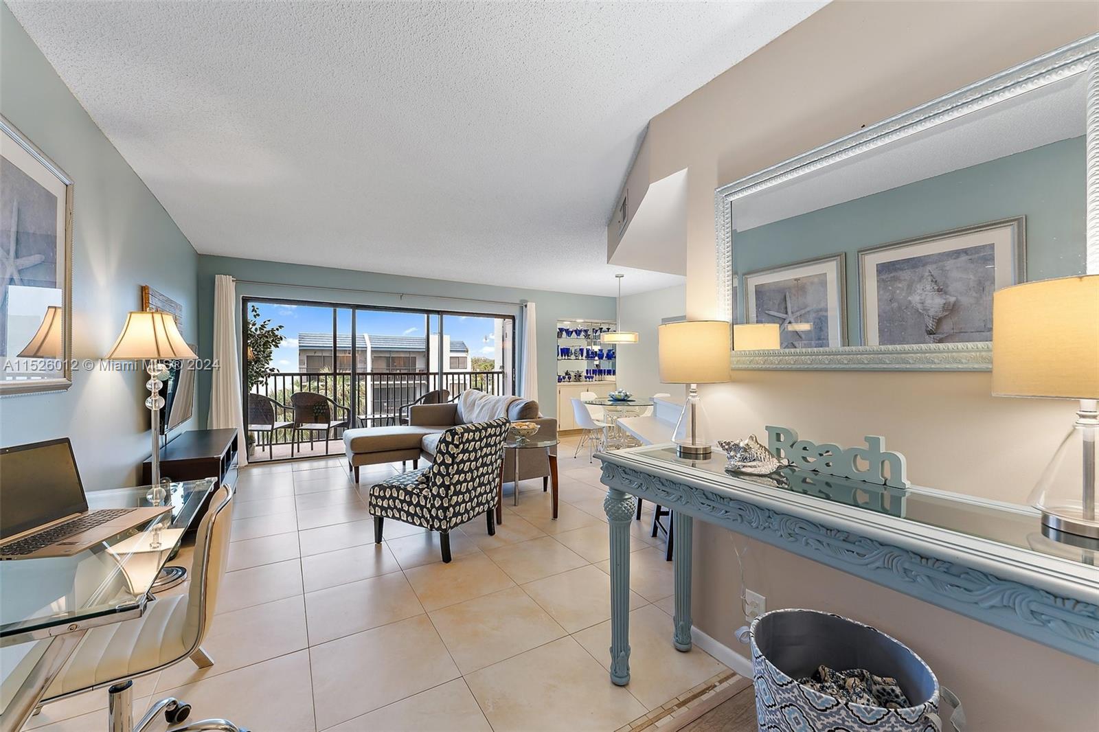 1605 Highway 1, Unit A406 Jupiter, FL 33477 - Photo 4 of 26 a living room with furniture and a lamp