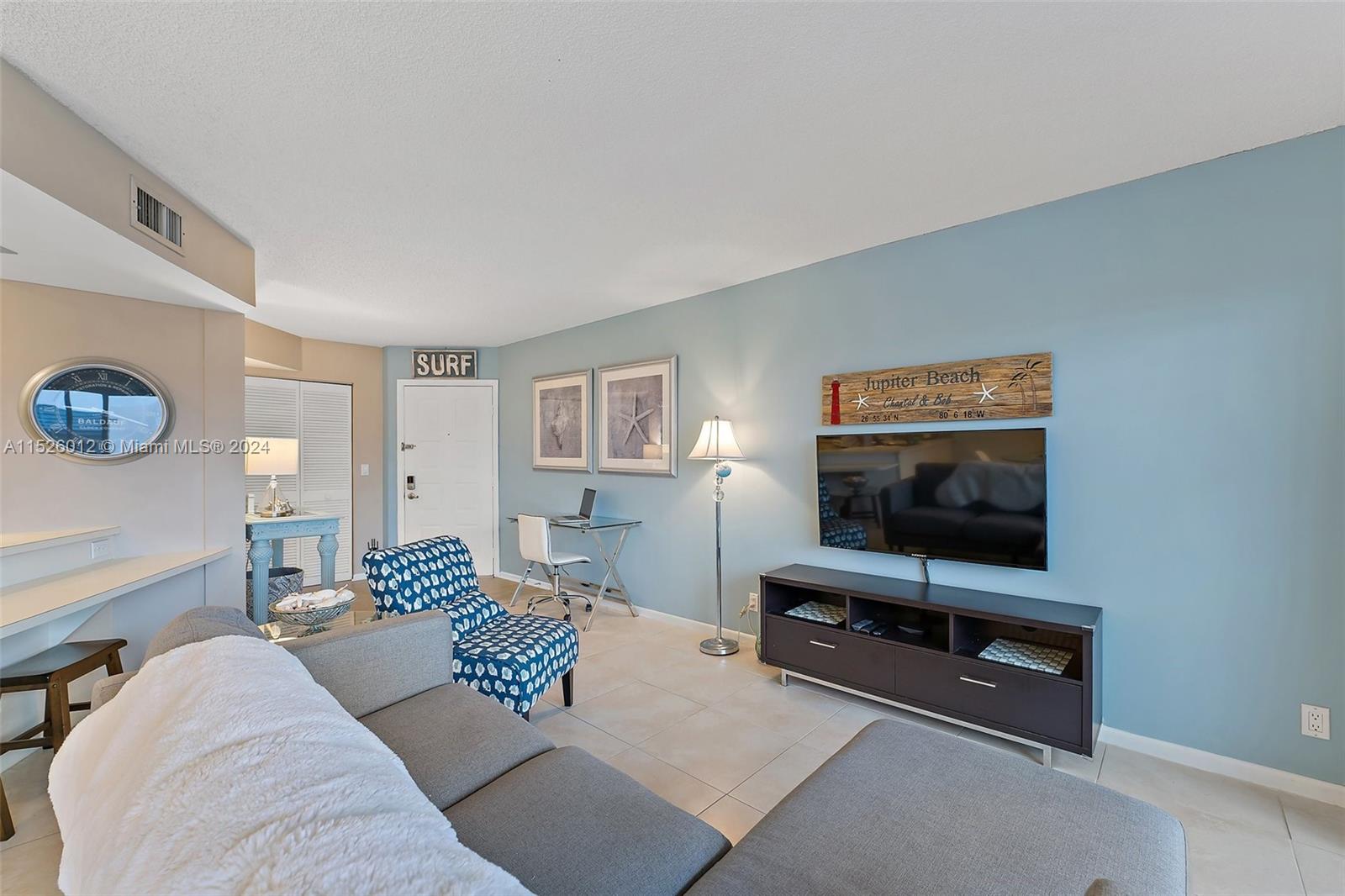 1605 Highway 1, Unit A406 Jupiter, FL 33477 - Photo 8 of 26 a living room with furniture and a flat screen tv
