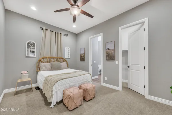 a bedroom with a large bed and a chandelier