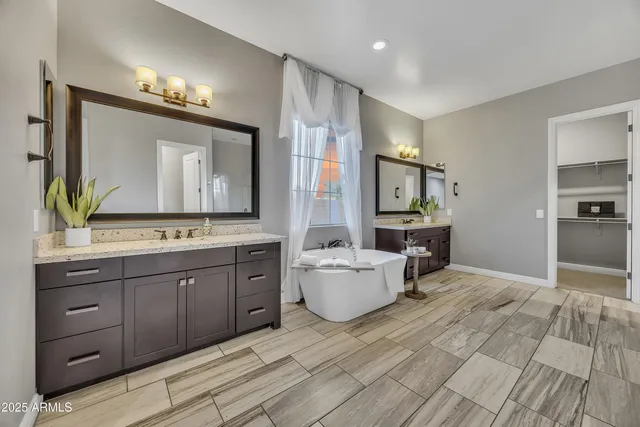 a spacious bathroom with a double vanity sink a large mirror and a shower