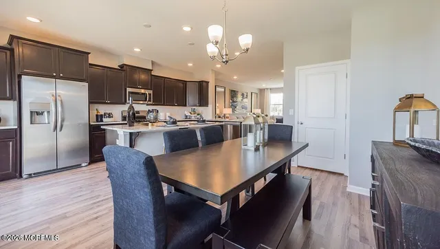 a kitchen with a dining table chairs stainless steel appliances and cabinets