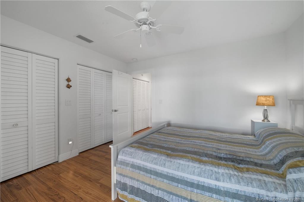 2929 Southeast Ocean Boulevard, Unit K7 Stuart, FL 34996 - Photo 14 of 18 a bedroom with a bed and a chandelier
