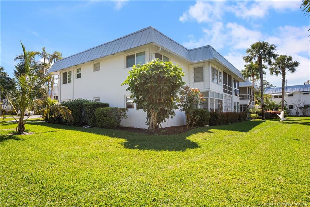 2929 Southeast Ocean Boulevard, Unit K7 Stuart, FL 34996 - Photo 2 of 18 a front view of house with yard and swimming pool