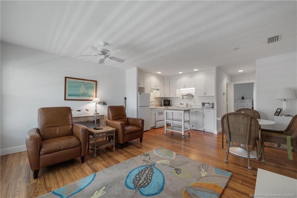 2929 Southeast Ocean Boulevard, Unit K7 Stuart, FL 34996 - Photo 5 of 18 a living room with furniture a rug and kitchen view