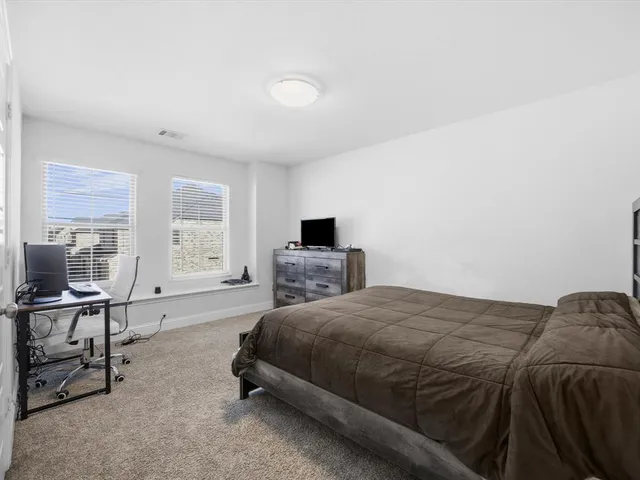 a bedroom with a bed a desk and chair