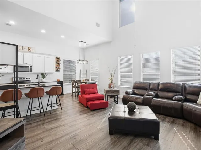 a living room with furniture kitchen view and a large window