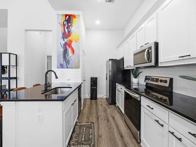 a kitchen with stainless steel appliances granite countertop a sink and a stove top oven