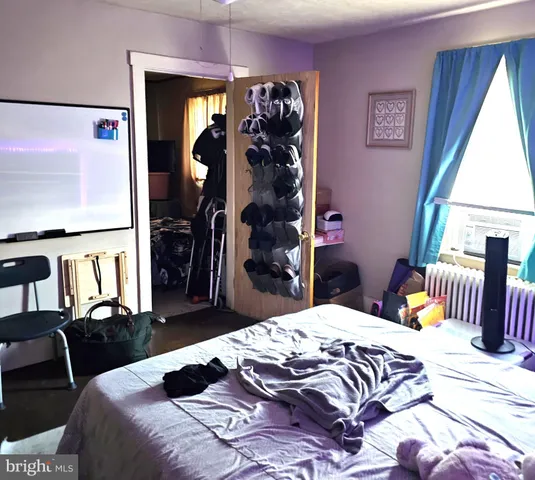 a bedroom with a bed and a large mirror on the dresser