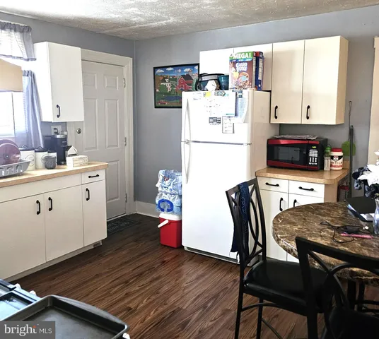 a kitchen with a table chairs and a refrigerator