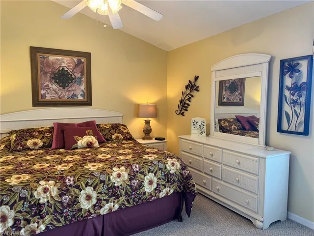 a bedroom with a large bed and a painting on the wall