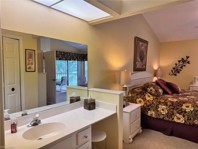 a en suite bathroom with a granite countertop sink and a mirror