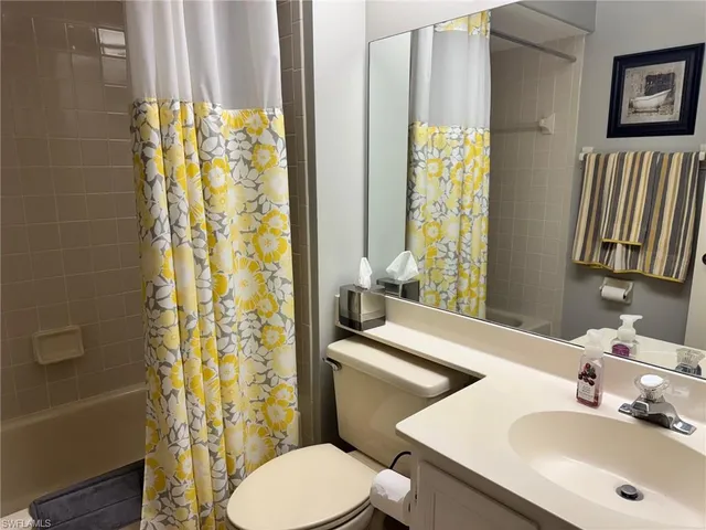 a bathroom with a sink a toilet and shower curtain