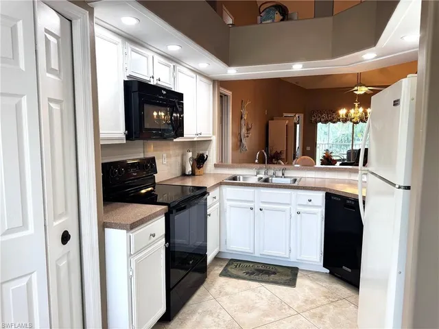 a kitchen with a sink and a stove top oven with wooden floor